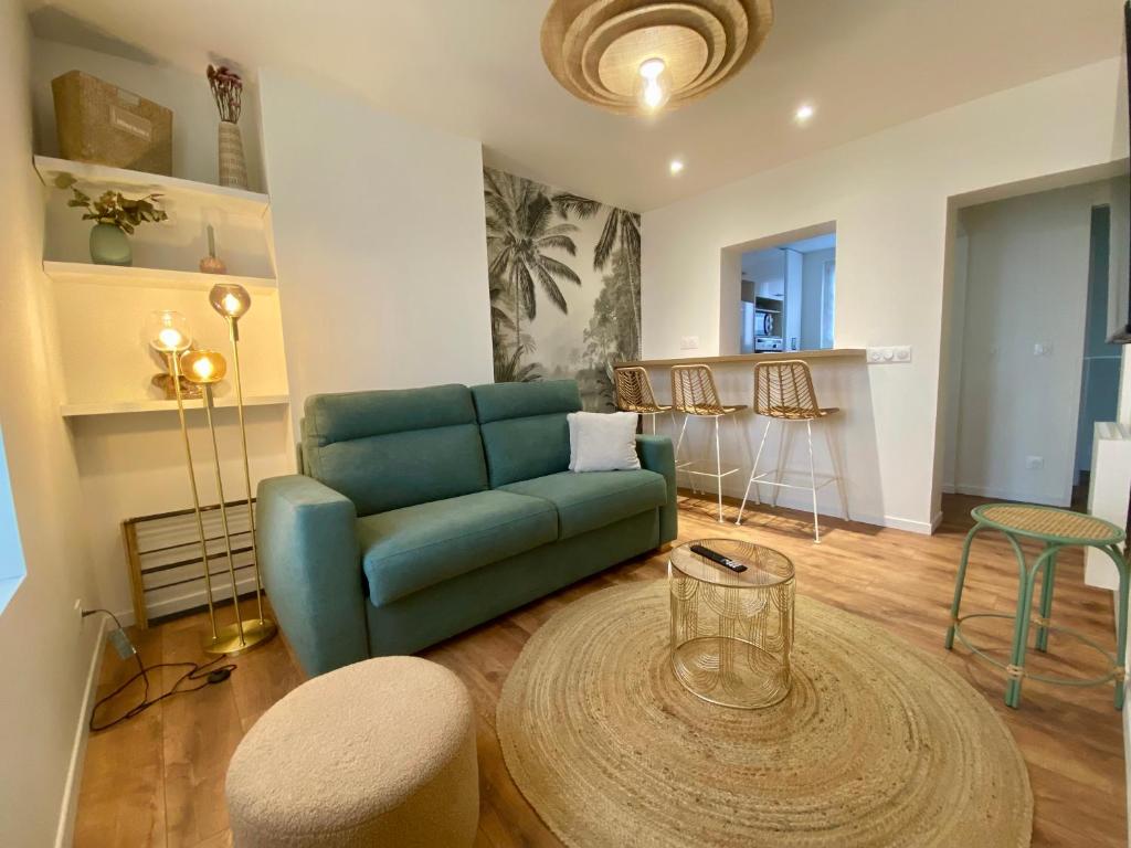 een woonkamer met een blauwe bank en een tafel bij Haut Chatelet in Orléans