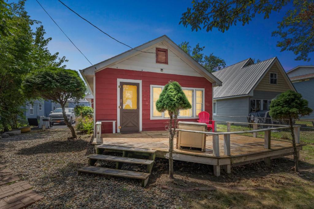 une maison rouge et blanche avec une terrasse couverte dans l'établissement Dave's Last Resort-House on the Lake home, à Monticello