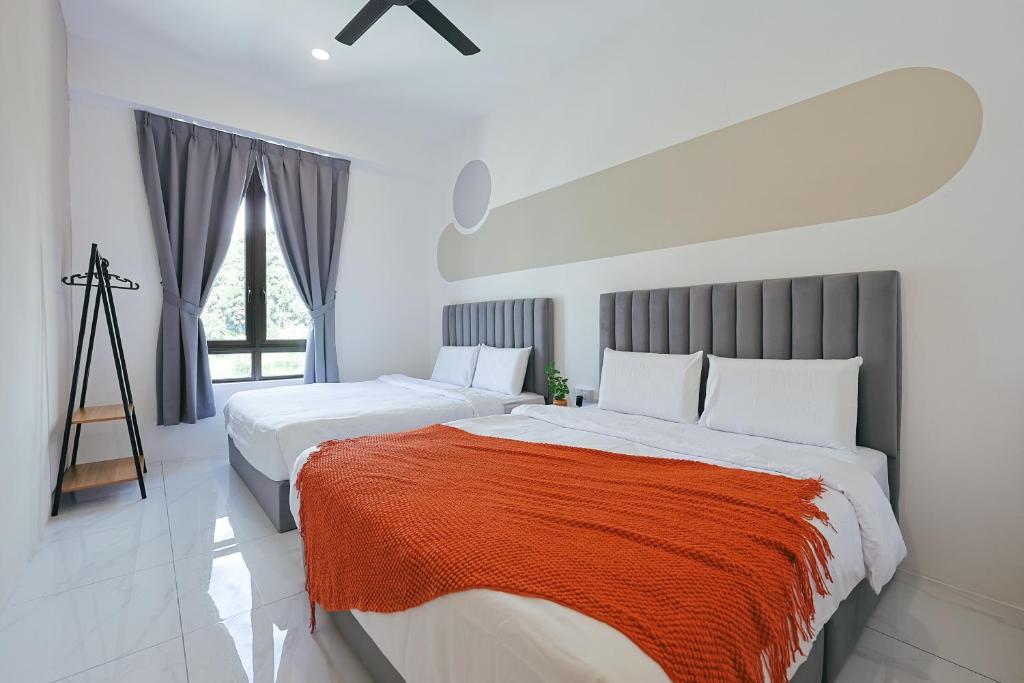 a white bedroom with two beds with orange blanket at Cameron Centrum JoyStay Kids Fun Zone Clover Home A-2-15 A in Brinchang