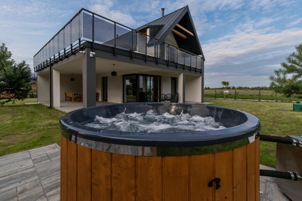 a house with a large wooden barrelpool in front of a building at Cztery Pory Roku in Januszkowo