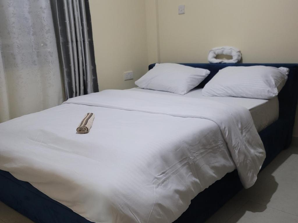 Un dormitorio con una cama con Aigil encima. en 2 Bedroom in Nairobi, en Nairobi
