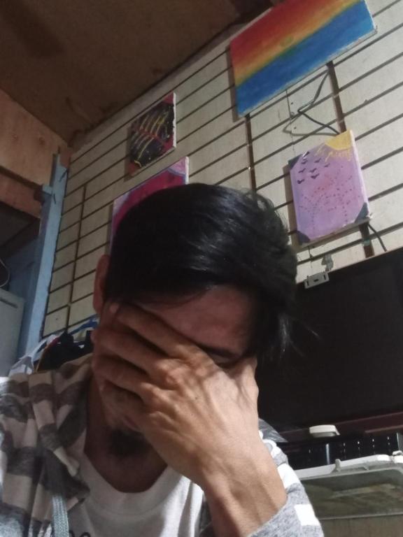 un hombre cubriéndose la cara con las manos en Cebu city, en Cebú