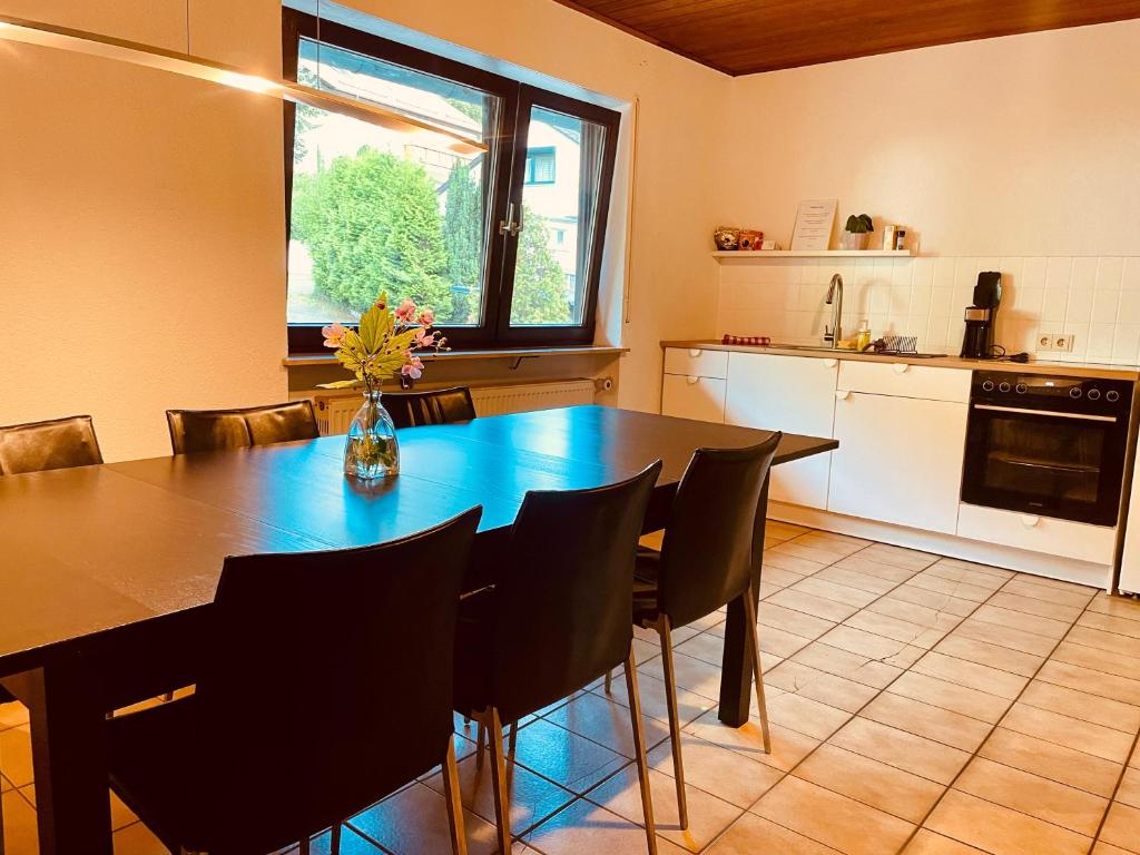 een keuken met een eettafel en stoelen bij Wohnung im Landhaus - Waldblick, Balkon & Garten in Trösel