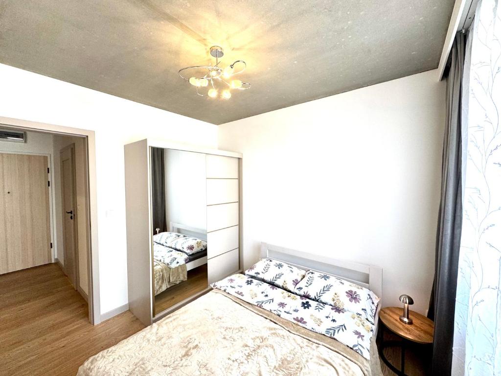 クラクフにあるApartament Piastów - PARKINGのベッドと鏡のある寝室