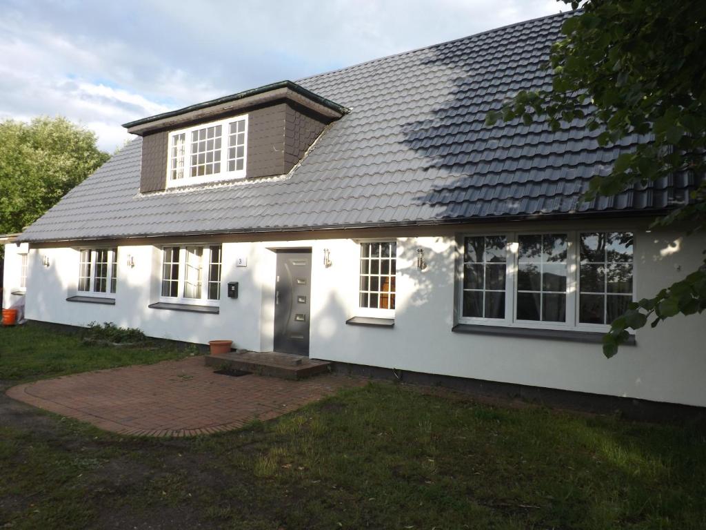 a white house with a gray roof at Borstel - Alte Schmiede in Borstel