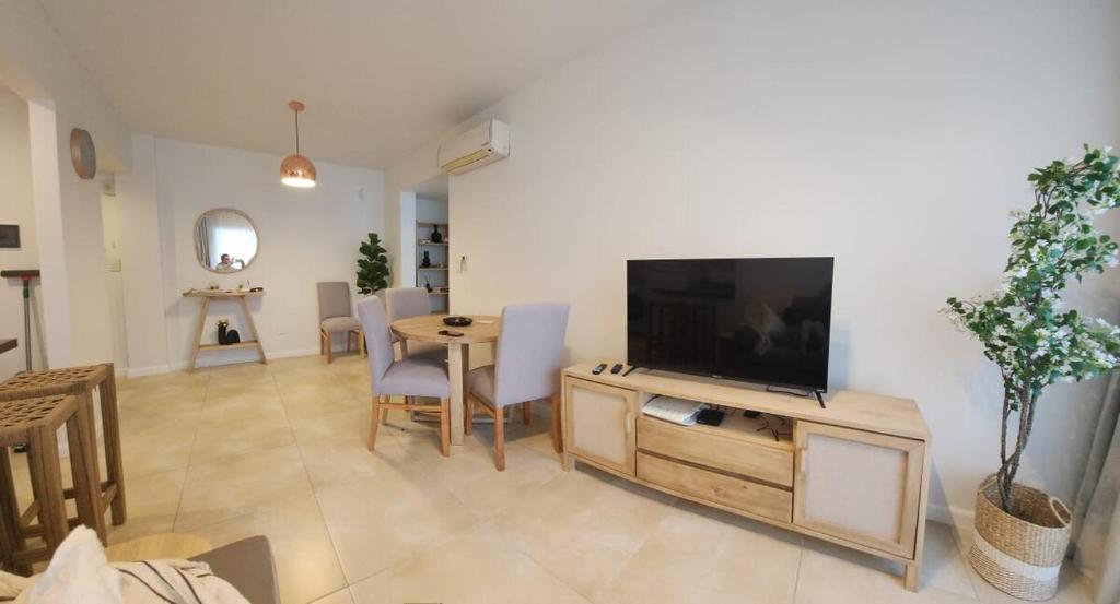 un salon avec une télévision à écran plat et une table dans l'établissement Departamento Banfield Centro, à Lomas de Zamora