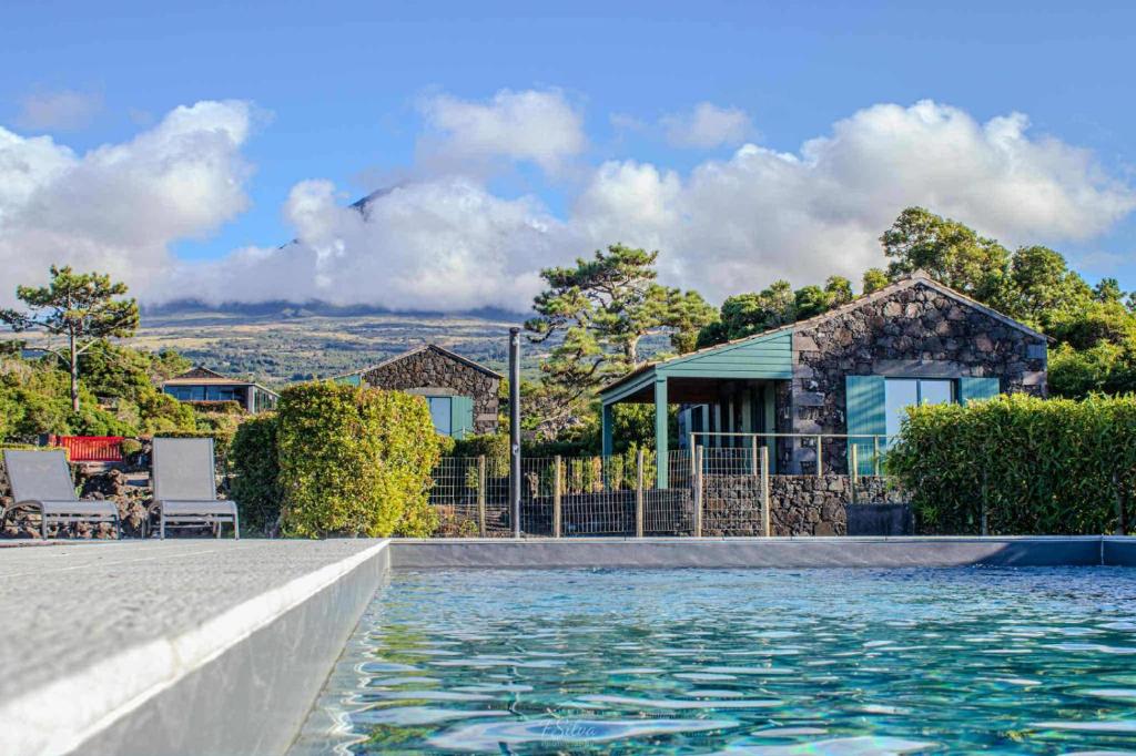 a house with a swimming pool in front of a house at Refúgio da Montanha in Lajido