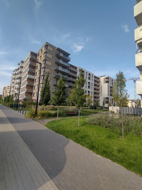 a sidewalk in a park with tall buildings at New Apartment Wroclaw Parking Place & Self Check in 24H Apartament TARAS Miedziana in Wrocław