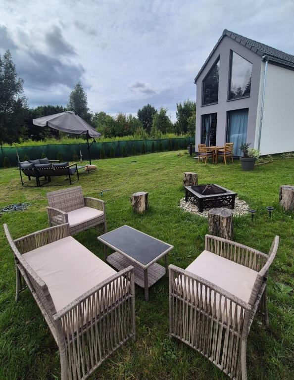 a group of chairs and tables in front of a house at Chill in Lubrza in Lubrza