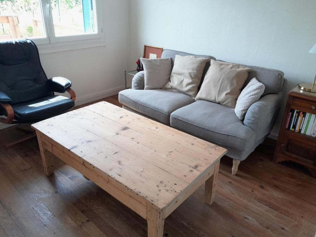 a living room with a couch and a coffee table at Le calme près de la ville in Saumur