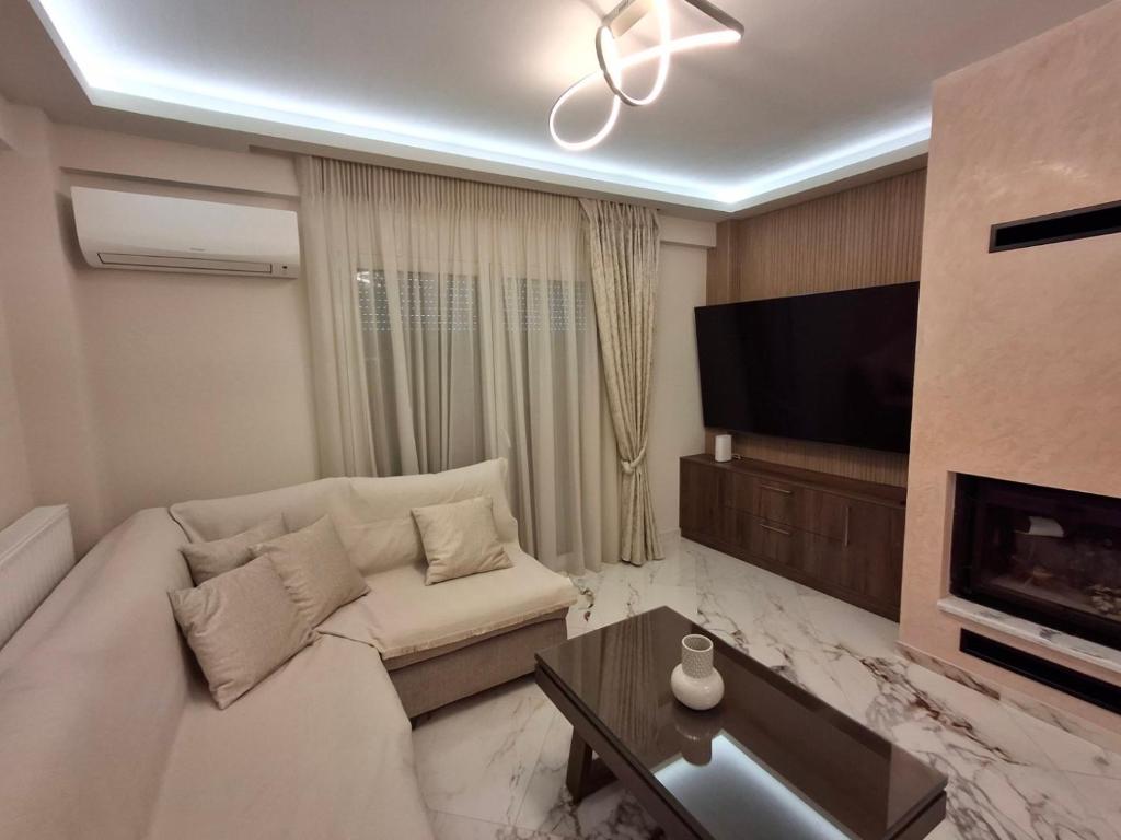a living room with a white couch and a television at Luxury Maisonette in Ioannina