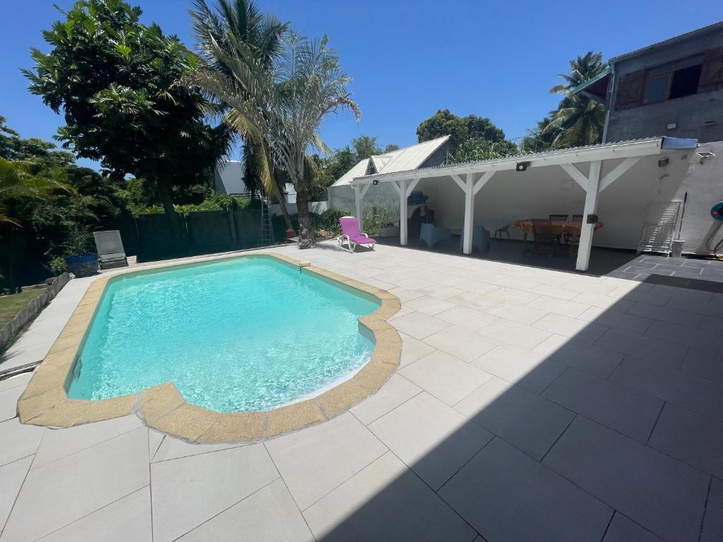 una piscina in un cortile con una casa di Studio piscine centre Gosier a Le Gosier