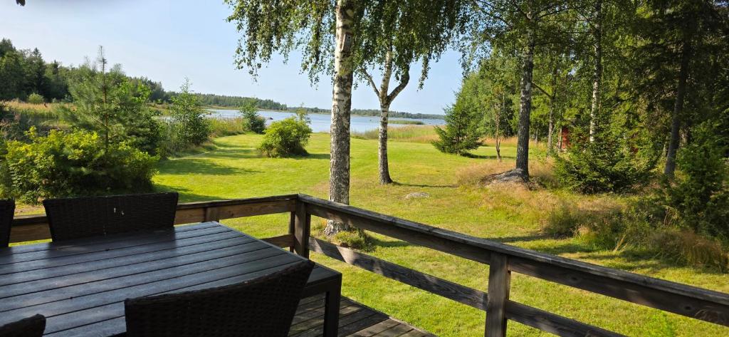 a wooden deck with a table and a view of a lake at Merenkurkku in Molpe