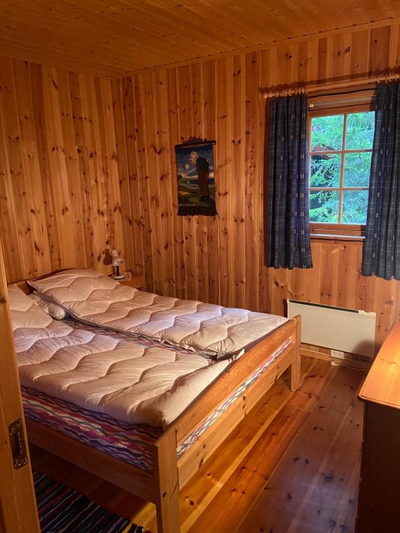 una camera da letto con un letto in una stanza di legno di Det er en fantastisk og romslig hytte i Slemdalen, Nordre Osen! a Åmot