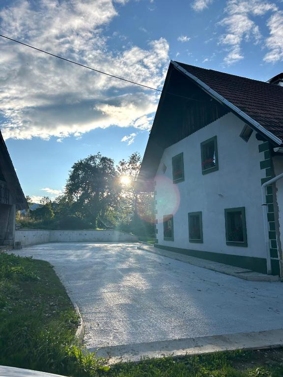 a building with the sun setting behind it at Bohinj Countryside House in Bohinjska Bistrica