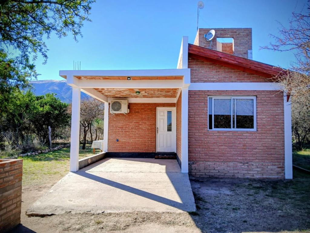 un edificio in mattoni rossi con una porta bianca di La Porteña a Cortaderas