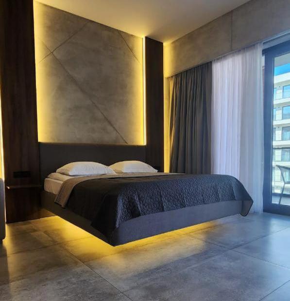 una camera da letto con un letto con una grande testiera di Park Residence 2 a Nardaran