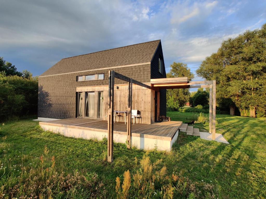 a brick house with a deck in the grass at Dom Szumią Wierzby in Szumlin