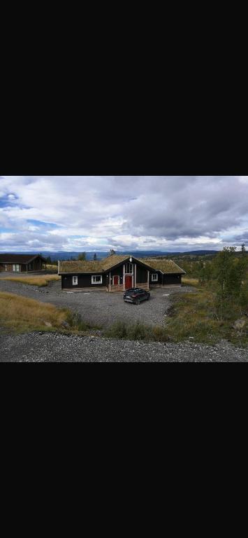 a house with a car parked in front of it at Hytte hafjell mosetertoppen in Øyer