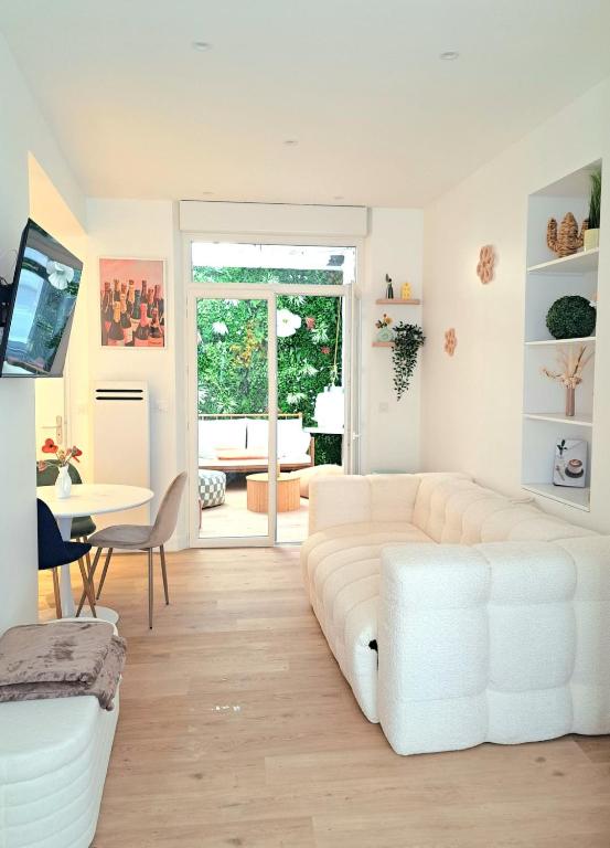 a living room with a white couch and a table at Au Détour des Sacres -Hypercentre-Boulingrin in Reims