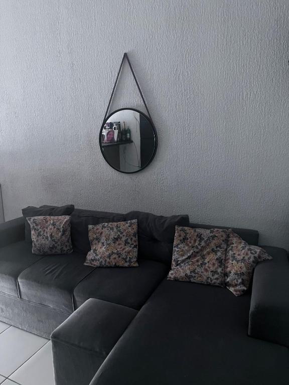 een woonkamer met een bank en een spiegel bij Condomínio Moradas Club Rios do Pará COP 30 in Ananindeua