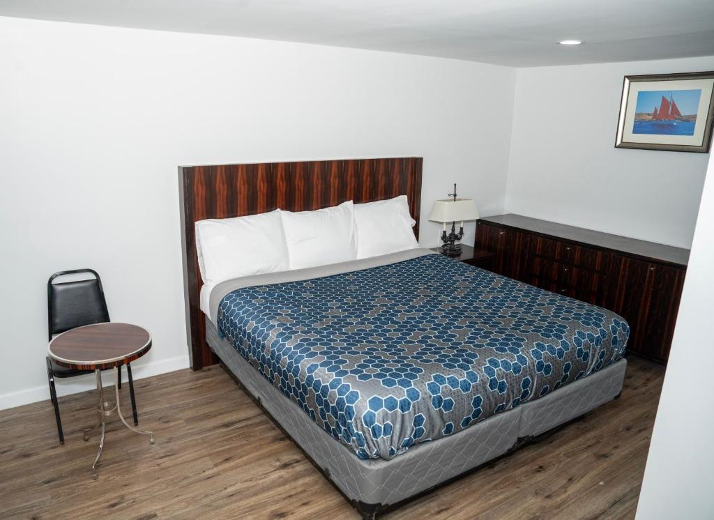 a bedroom with a bed and a table and a chair at Rainbow Motel in Douglassville