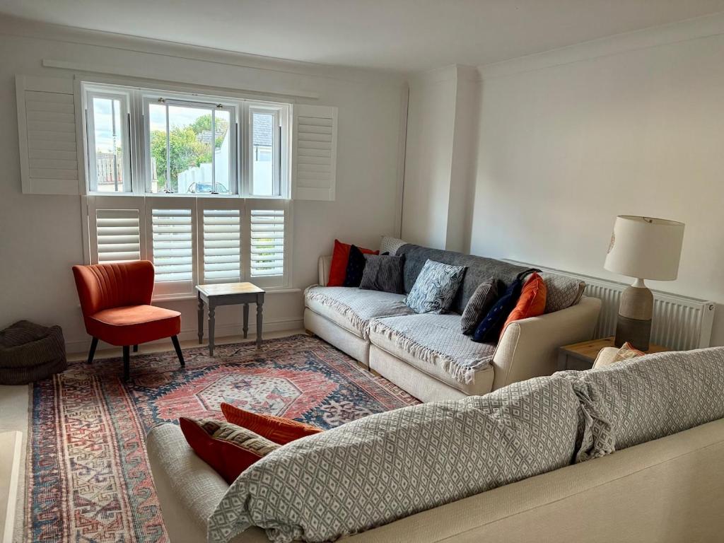 a living room with a couch and a chair at Charmouth Sea House by the beach in Charmouth