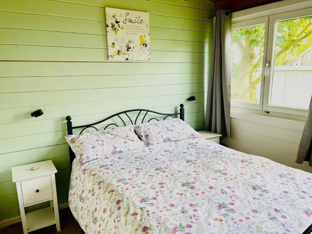 a bedroom with a bed with pink flowers on it at Walland Cottage Romney Retreat in Old Romney