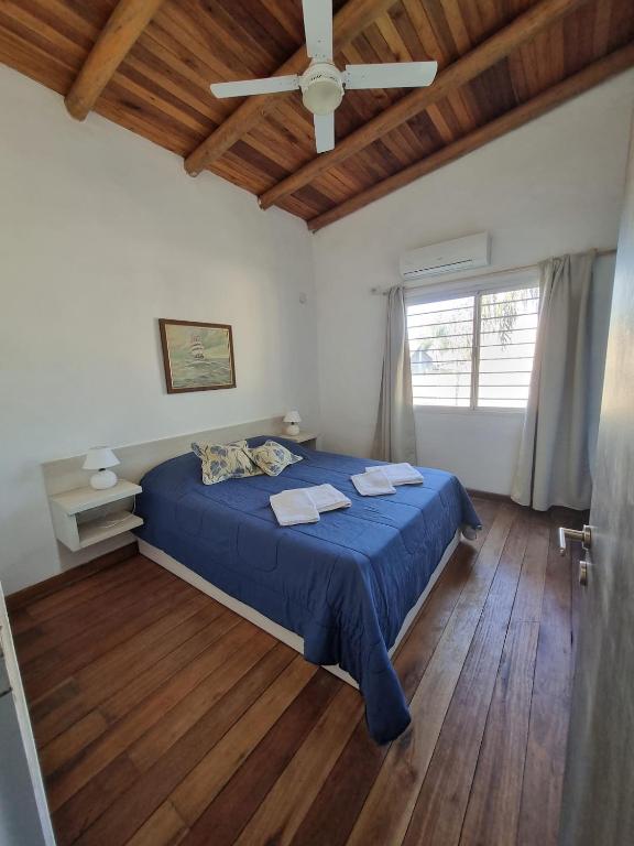 a bedroom with a blue bed with a ceiling fan at Pindó II - Expresión de buen gusto in Concordia