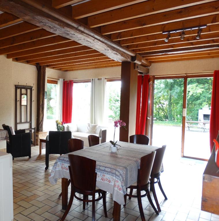 une salle à manger avec une table et des chaises dans l'établissement Gîtes de la Ferme Auberge de Mésauboin, à Billé