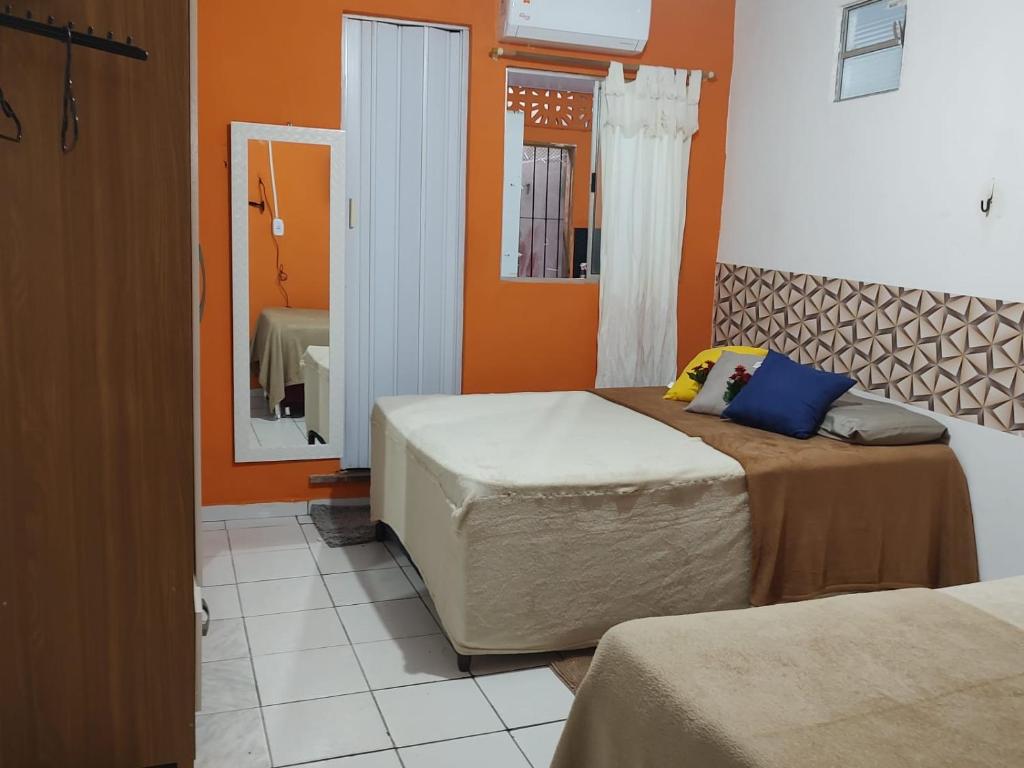 a bedroom with two beds and a mirror at Casarão 3 quartos com ar e garagem in Belém