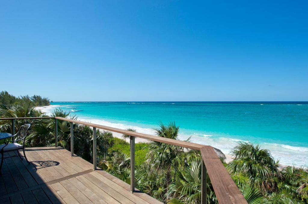 una scala in legno che conduce a una spiaggia con oceano di Aqua Villa and Cottage home a Governorʼs Harbour