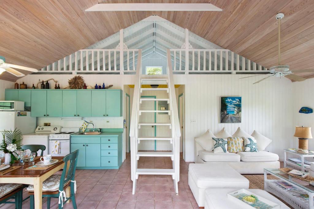 une chambre avec un lit mezzanine et une cuisine dans l'établissement Orchid Cottage cottage, à Governorʼs Harbour