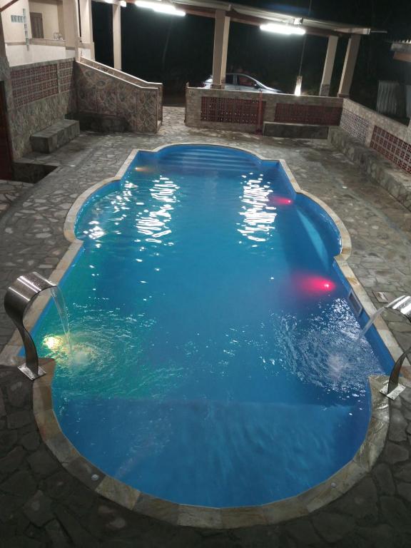 a large blue swimming pool at night at Chácara Recanto das Pedras in Guarulhos
