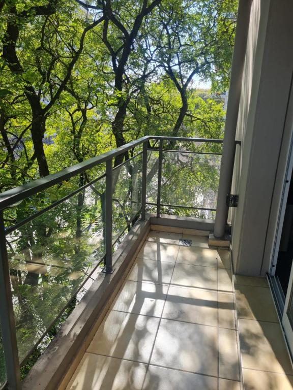 einen Balkon eines Hauses mit Blick auf die Bäume in der Unterkunft Armonia in Rosario