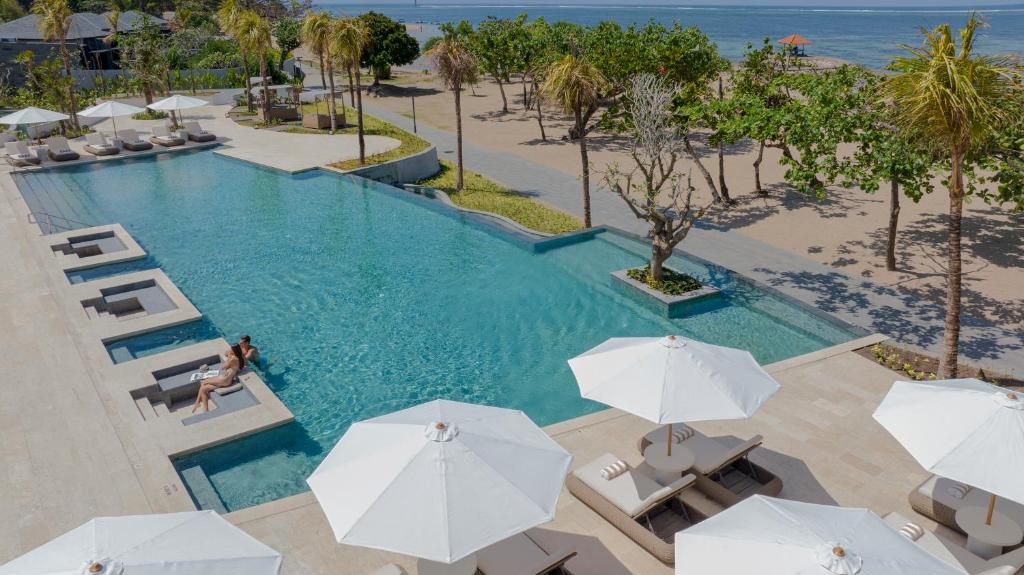 an overhead view of a swimming pool with chairs and umbrellas at Sumitra Luxury Villas & Resort by Pramana in Sanur