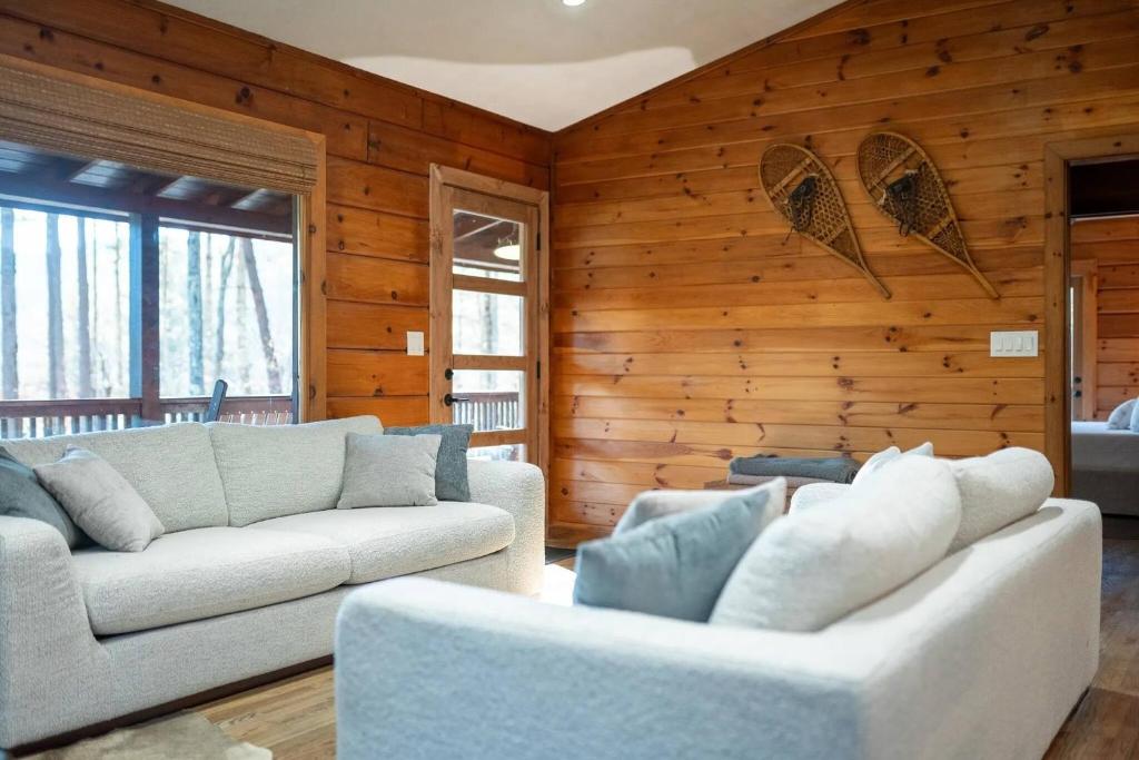 a living room with two couches and wooden walls at Aska's Cozy Corner Cabin in Cherry Log