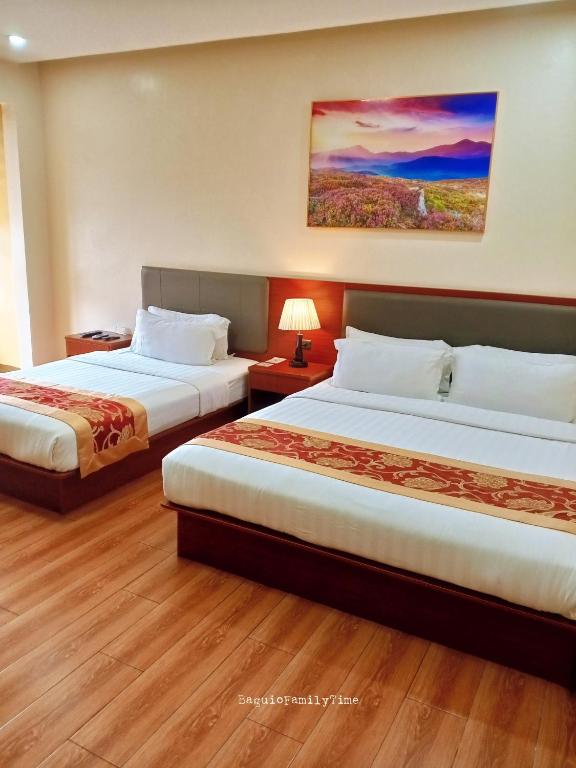 a hotel room with two beds and a painting on the wall at Starway Hotel and Restaurant in Baguio
