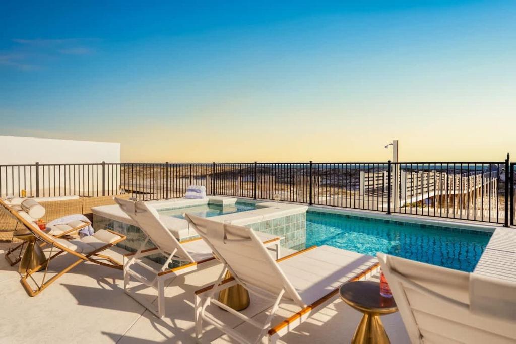 a swimming pool with lounge chairs and a swimming pool at Miramare - Beachfront Luxury with Pool & Elevator in Orange Beach