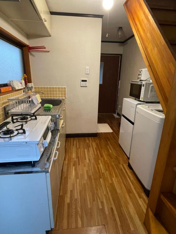 una cocina con estufa y hornilla horno superior en Popotel Three Room Z, en Matsumoto