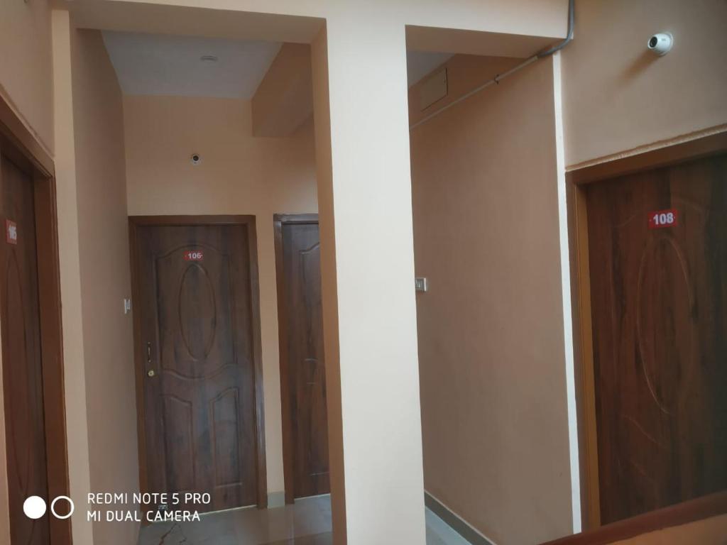a hallway with two wooden doors in a building at Royal Residency in Mahabalipuram