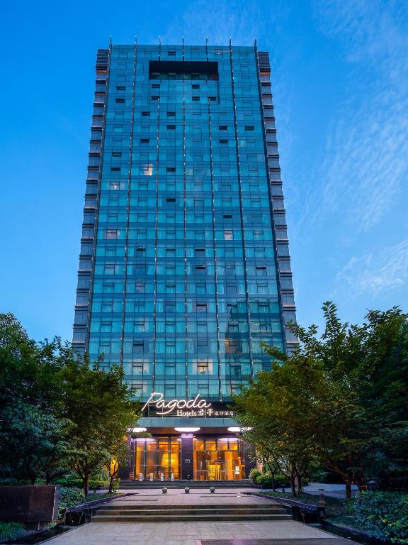 a tall building with a restaurant in front of it at Pagoda Hotel Hangzhou West Lake Wulin - City Center and Family Friendly in Hangzhou
