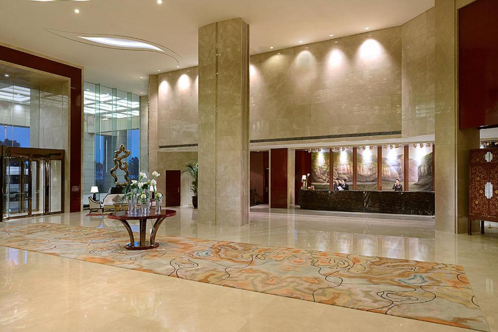 eine Lobby mit einem Tisch in der Mitte eines Gebäudes in der Unterkunft Crowne Plaza Zhenjiang by IHG in Zhenjiang