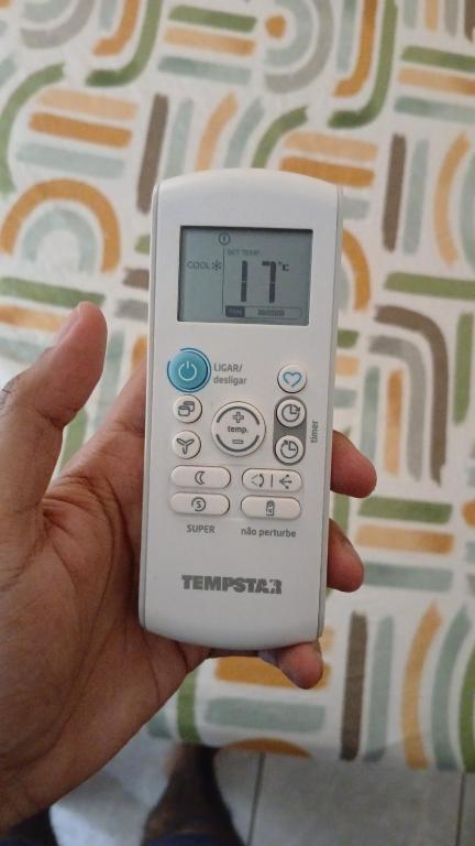 a person holding a remote control in their hand at Quarto Privado Cama Casal ou Individual Aeroporto in Rio de Janeiro