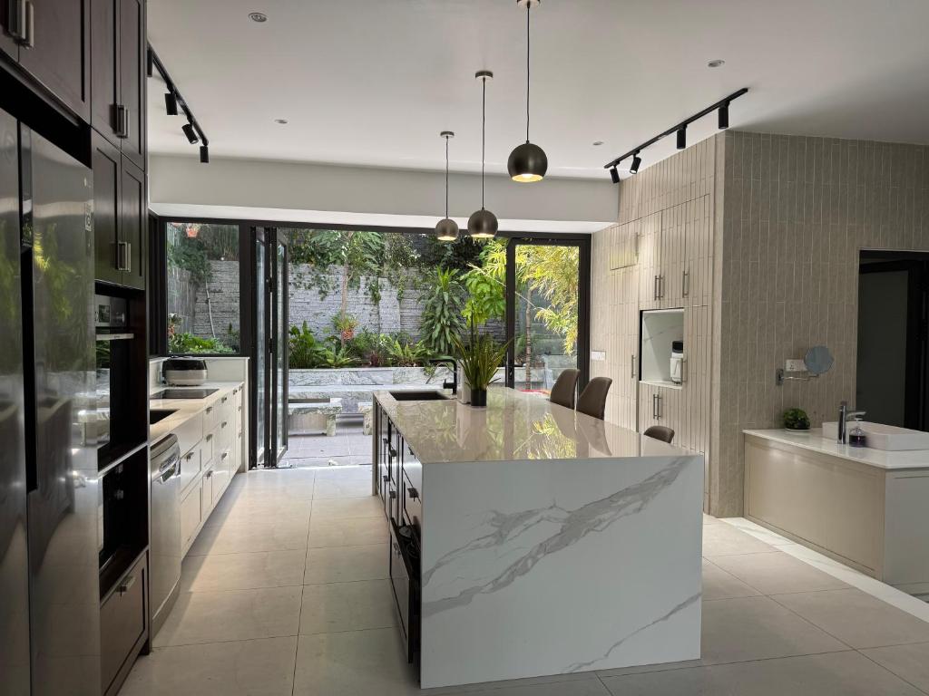 una cocina con una gran isla blanca en el centro en ZENVIRA POOL VILLA - Beach & Garden Retreat, en Nha Trang