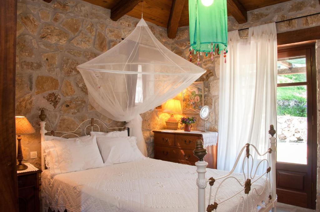 a bedroom with a white bed with a net at Villa Collina in Vasilikos