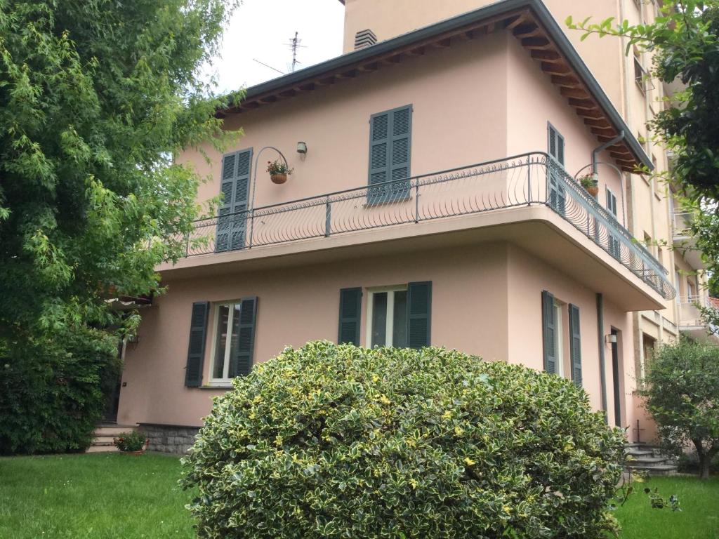 a house with a balcony and a bush in front of it at B&B Pescarenico in Lecco