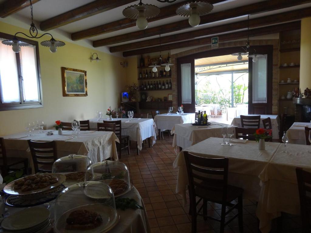 ein Restaurant mit Tischen und Stühlen sowie weißen Tischdecken in der Unterkunft Cà Francine in Gruaro