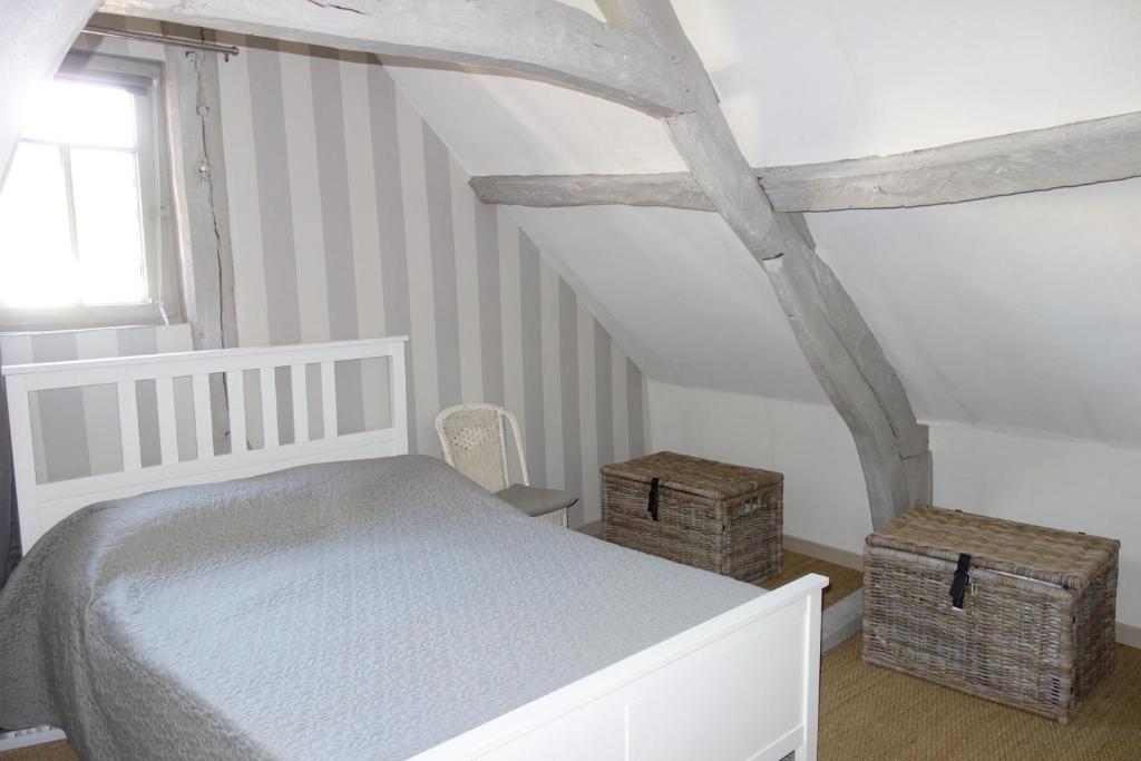 a bedroom with a white bed and two baskets at Boudin Cottage Honfleur in Honfleur