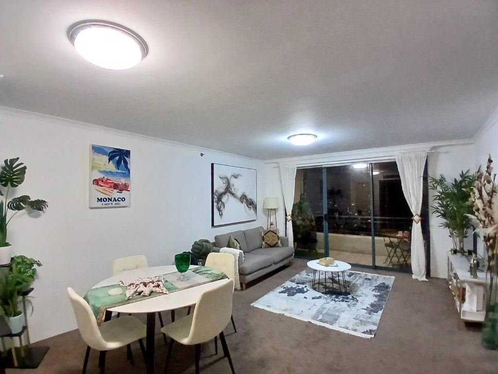 a living room with a table and a couch at Casa Blanca Haymarket in Sydney